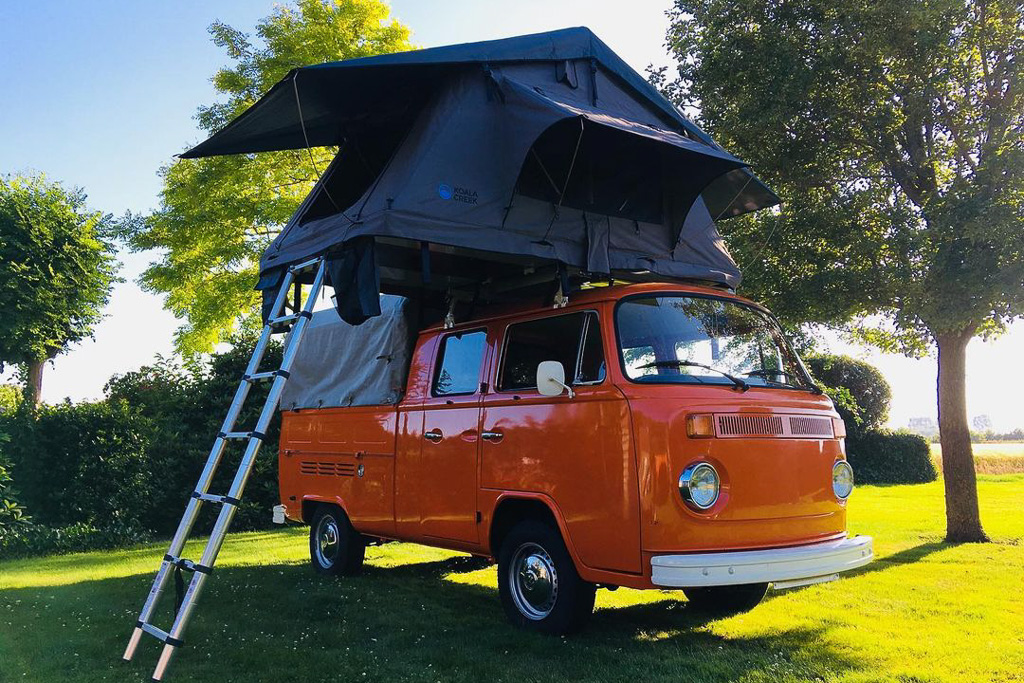 A classic VW crewcab van with a roof tent on top