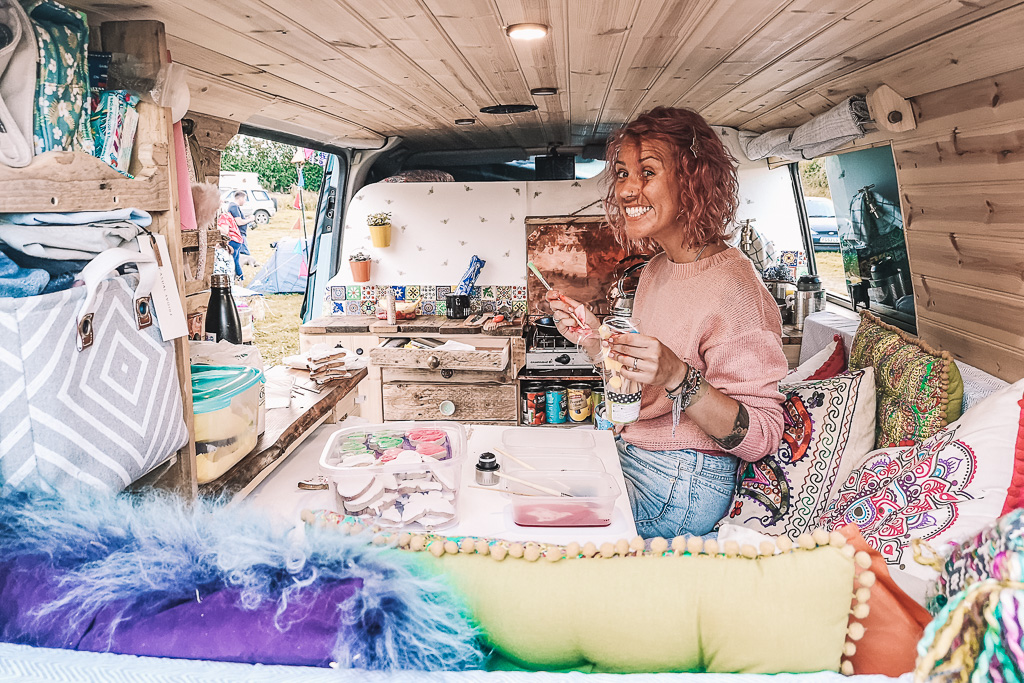 A lady decorating biscuits on a DIY camper table