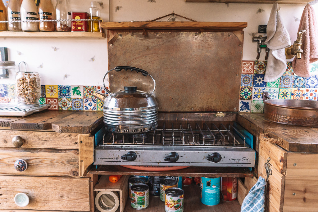 An upcycled camping cooker used in a campervan kitchen