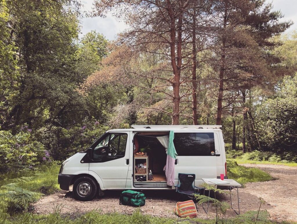 A white campervan in a forest