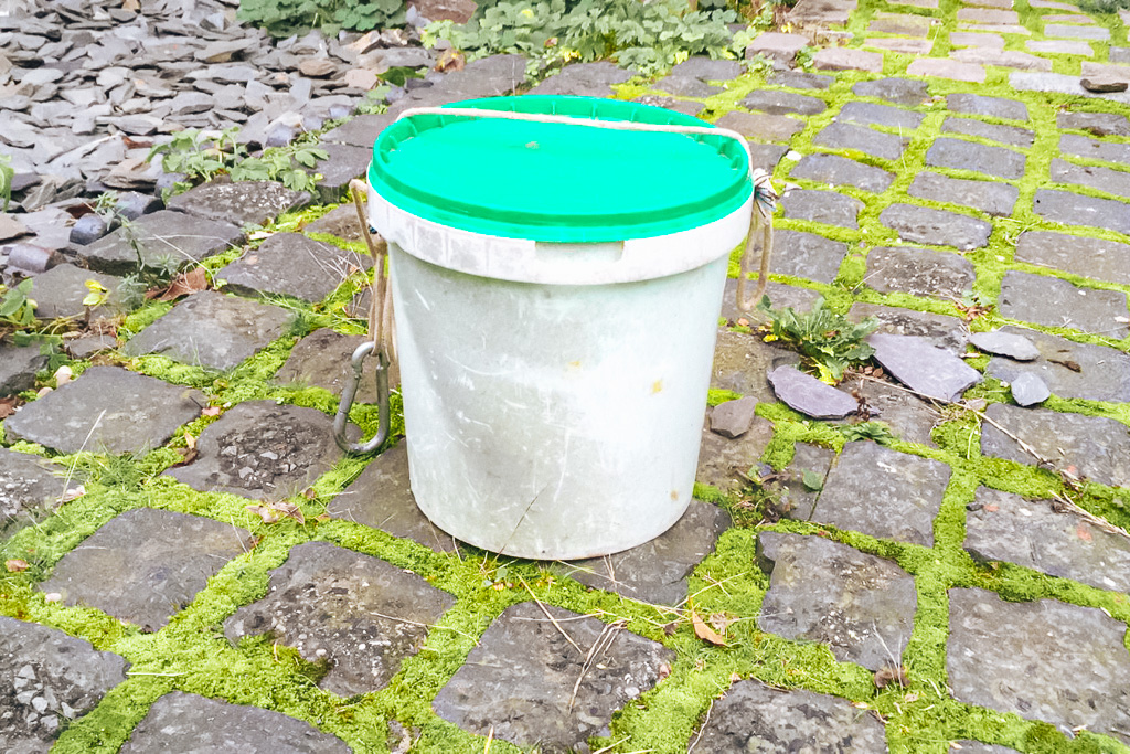 A portable campervan toilet bucket with the lid on